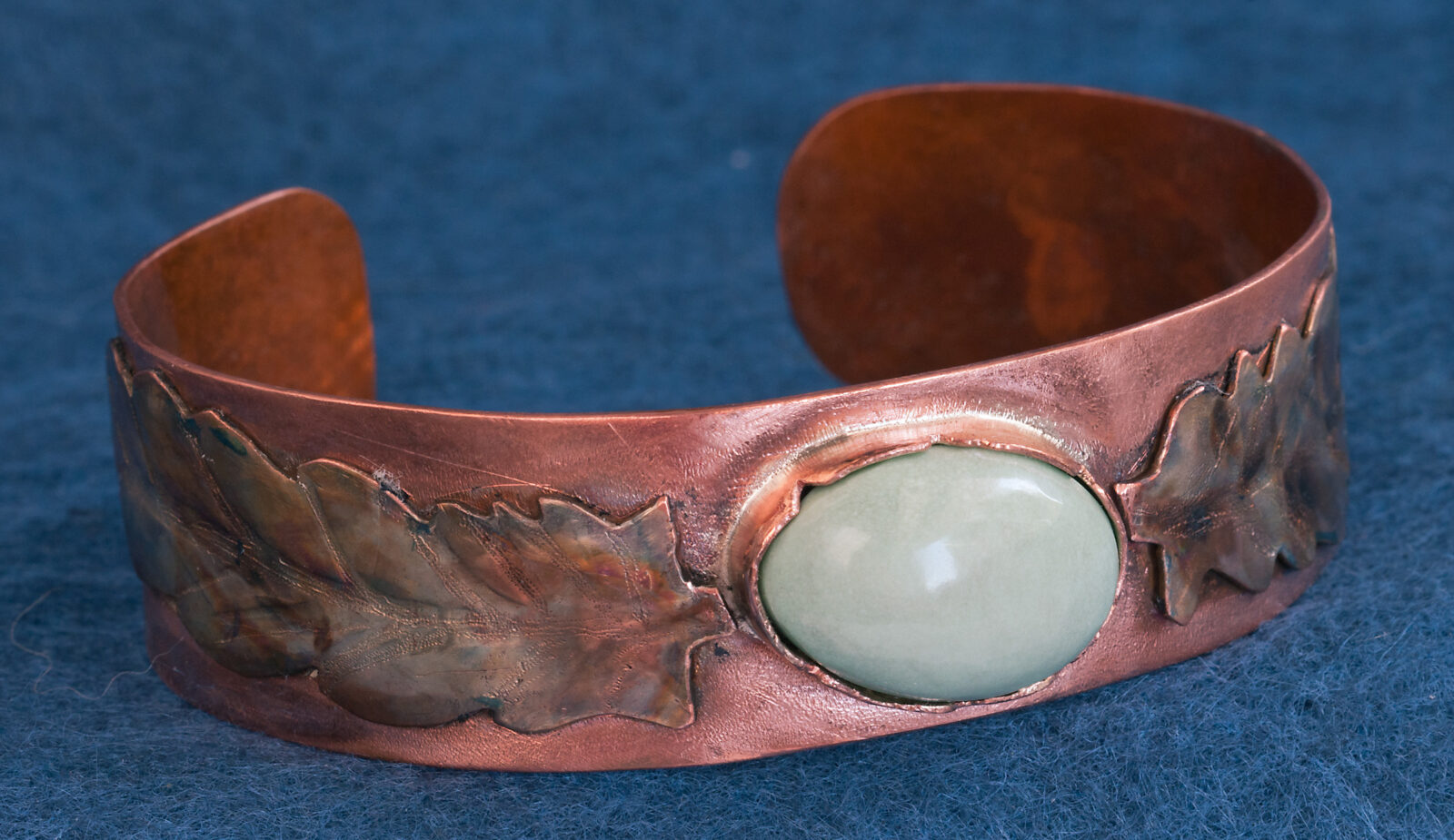 Copper cuff bracelet with leaf decoration, soft green stone